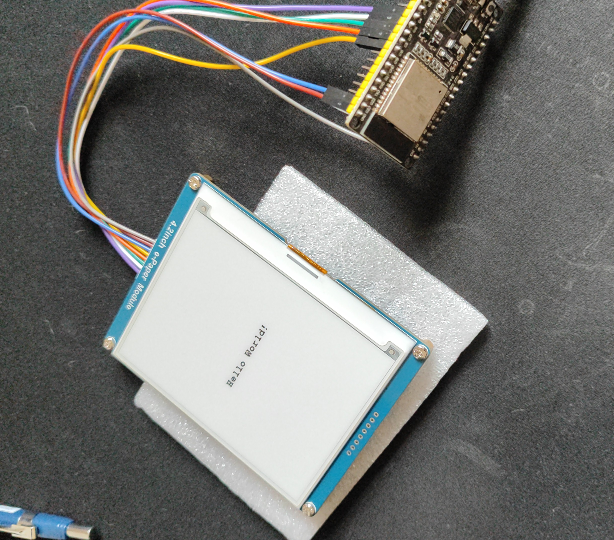 tela e-ink com a mensagem 'Hello World!' conectada a um ESP-32